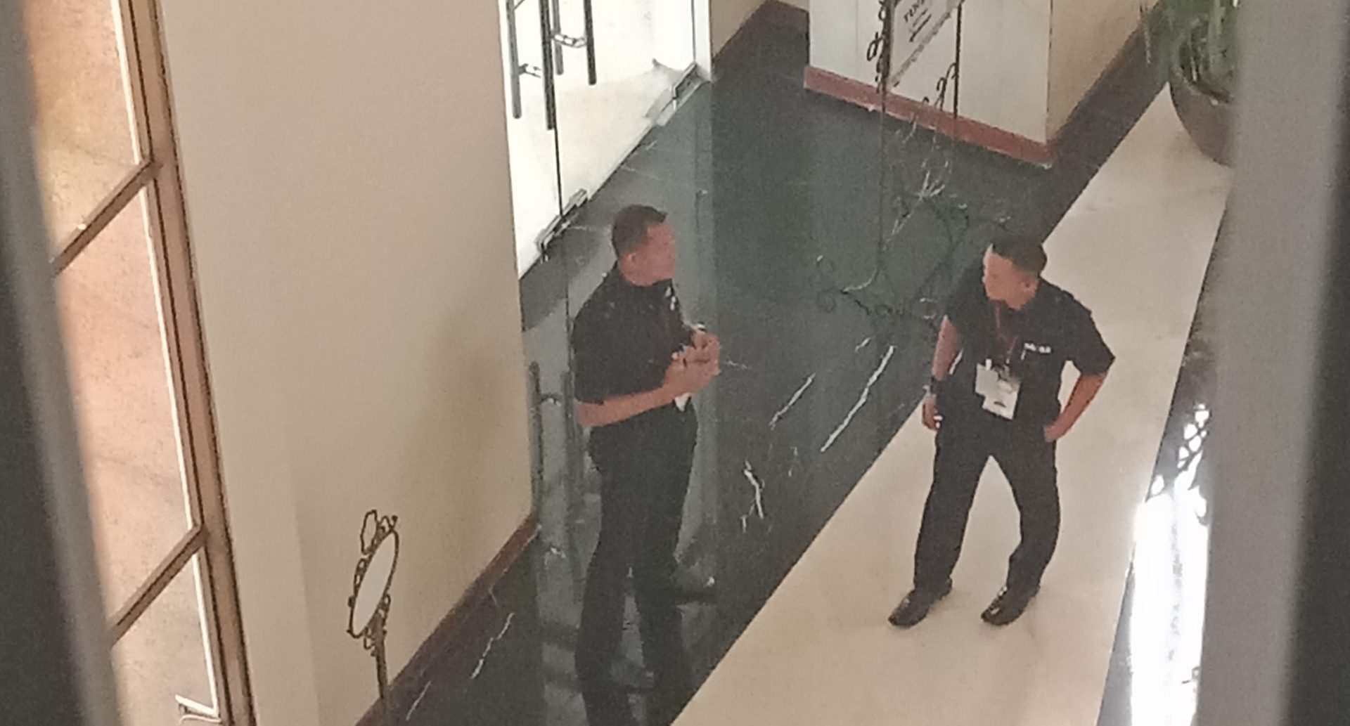 Top‑angle view of SAGAS security guards on duty in a lobby setting, as seen from a surveillance perspective