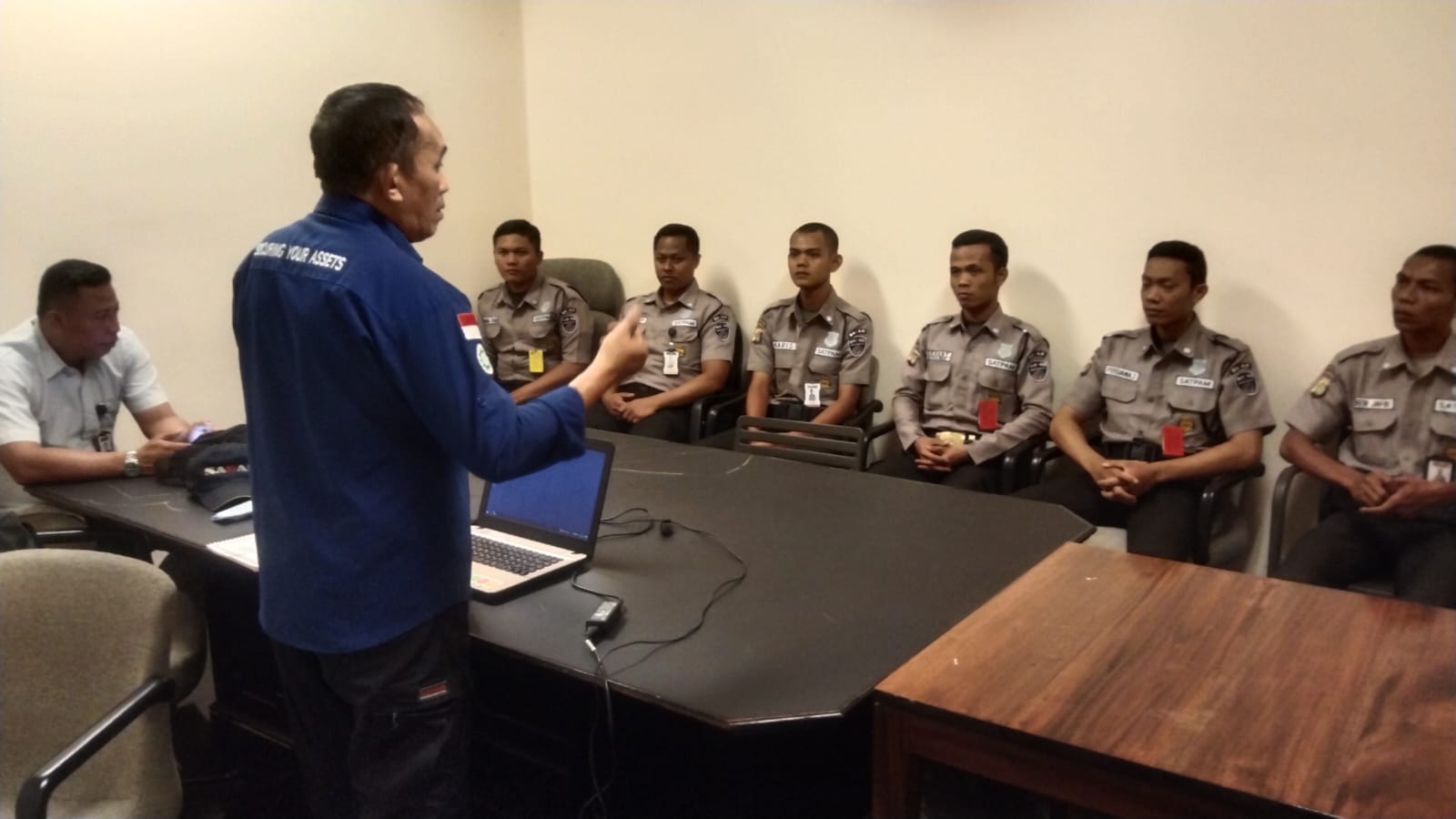 SAGAS supervisor giving an operational briefing to security guards in a command room setting