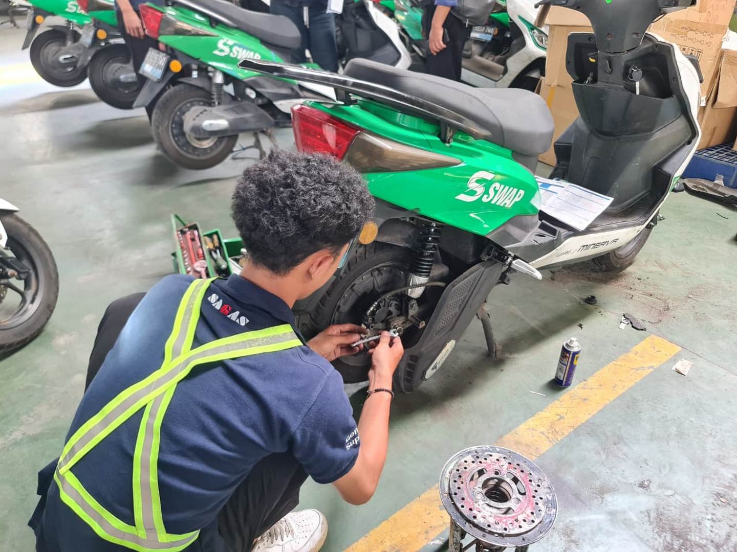 SAGAS technician inspecting electric motorbike equipment at client site in Indonesia as part of technical support services