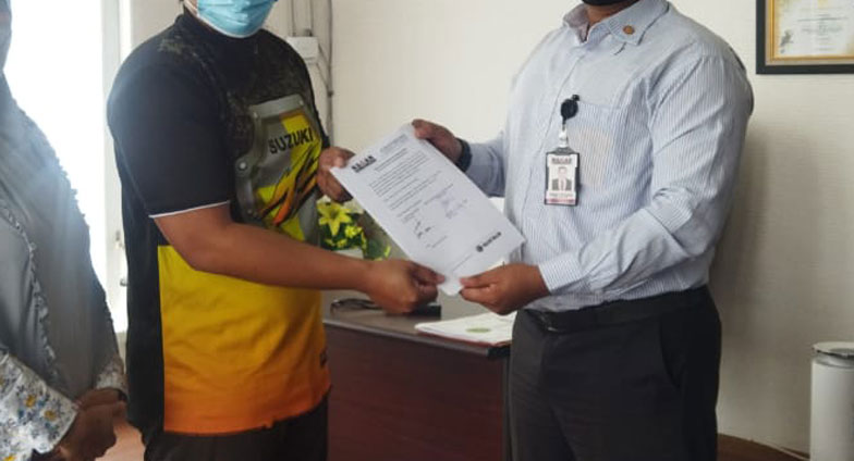 SAGAS security area coordinator shaking hands with a client while holding a signed document in Kalimantan, Indonesia