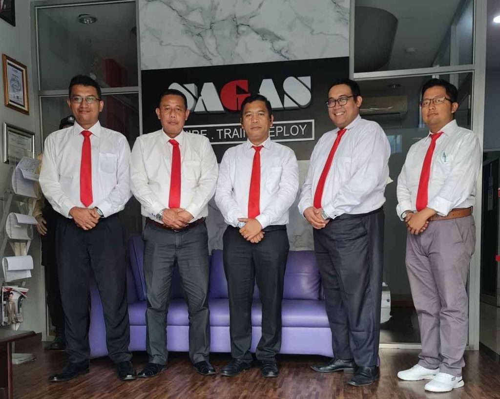 SAGAS security consultants, including director Tulus, at office reception with company logo in Indonesia